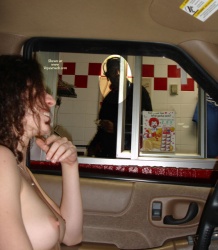 A female driver ordering food at a drive-in
