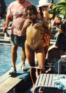 A random party girl with her panties at her knees licking her nipple