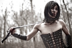 Bree outdoors wearing a collar and leash in her Gothic Vamp Leather get-up