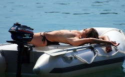 A topless gal relaxing on an inflatable raft